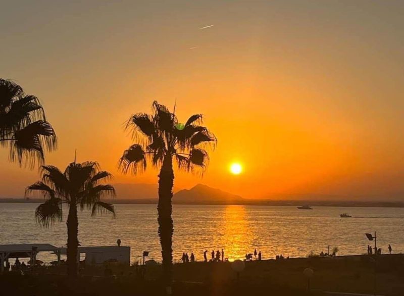 Na predaj apartmán - Mar Menor, Španielsko A500ZL - Západ slnka s palmami a morom v La Manga del Mar Menor, Španielsko.