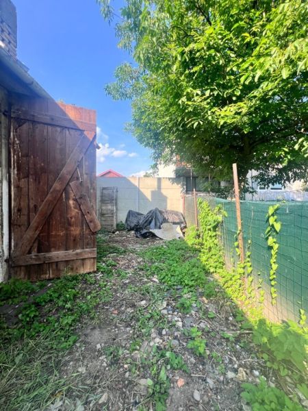 Na predaj vidiecky rodinný dom - Žarnovica/Brehy D045ZL - Záhrada rodinného domu v Brehoch, Nová Baňa, s drevenou bránou a stromom.