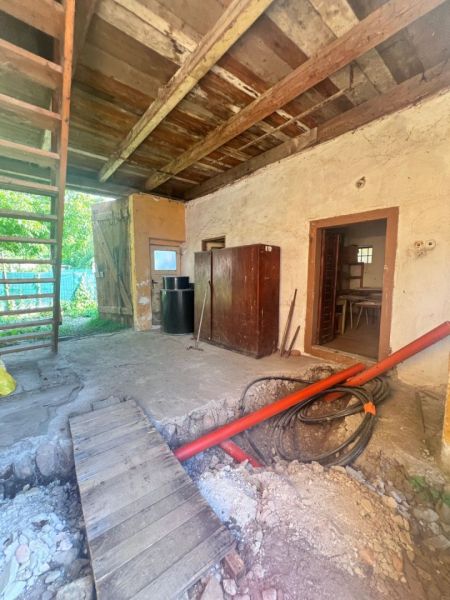 Na predaj vidiecky rodinný dom - Žarnovica/Brehy D045ZL - Interiér rodinného domu s dreveným stropom, rozkopanou podlahou a rebríkom.