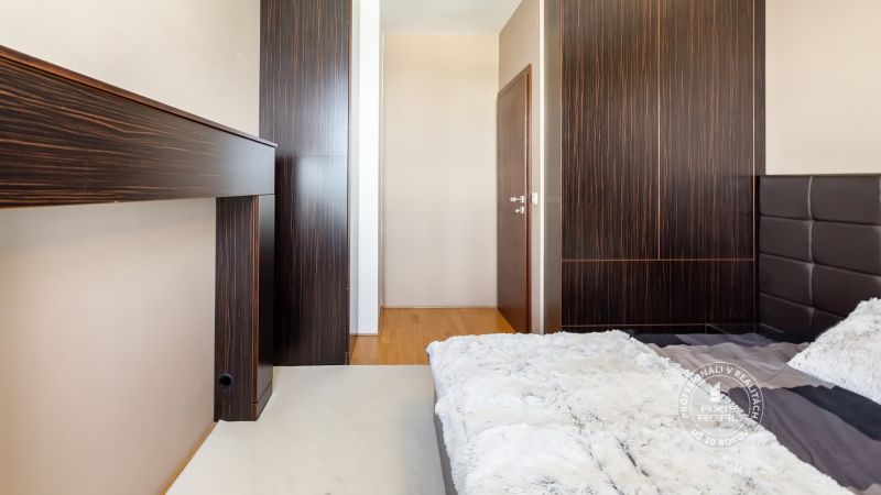 LUXUSNÝ 3-izb.byt, NOVOSTAVBA OCTOPUS, Mraziarenská ul. - Spálňa v 3-izbovom byte s tmavým nábytkom a posteľou s kožušinovým prehozom.