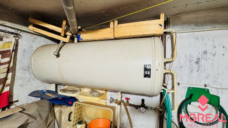 Na predaj 3 i byt so záhradou v Partizánskom – centrum - Boiler v technickej miestnosti 3-izbového bytu, potrubie, hadice, steny.