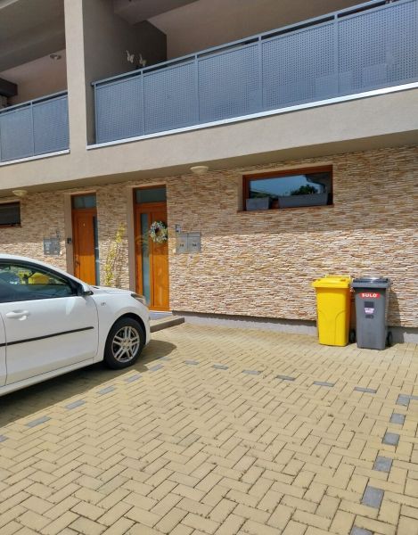 4-izb. byt v obci Veľký Biel, 2 x parkovacie miesto, terasa - Vchod a parkovisko 4-izbového bytu na Lipovej ulici vo Veľkom Bieli.