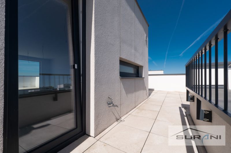 Nový 3-izbový byt 82 m² | Terasa 97 m² | Mesačná ulica | Hviezdoslavov - Terasa 3-izbového bytu na Mesačnej ulici v Hviezdoslavove s dlažbou a zábradlím.