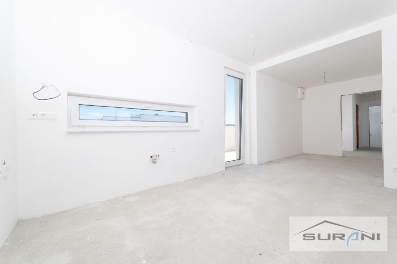 Nový 3-izbový byt 82 m² | Terasa 97 m² | Mesačná ulica | Hviezdoslavov - Prázdny interiér 3-izbového bytu s bielymi stenami a francúzskymi oknami.