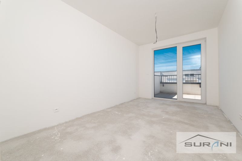 Nový 3-izbový byt 82 m² | Terasa 97 m² | Mesačná ulica | Hviezdoslavov - Prázdna izba v 3-izbovom byte so vstupom na balkón a nedokončenou podlahou.