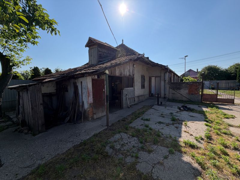 Rodinný dom s veľkým pozemkom v meste Nesvady  - Rodinný dom v Nesvadoch s poškodenou strechou a slnečným dvorom.