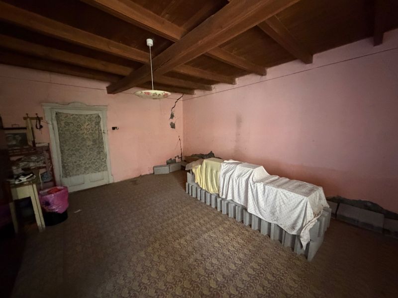 Rodinný dom s veľkým pozemkom v meste Nesvady  - Miestnosť v rodinnom dome so starožitným osvetlením a trámovým stropom.