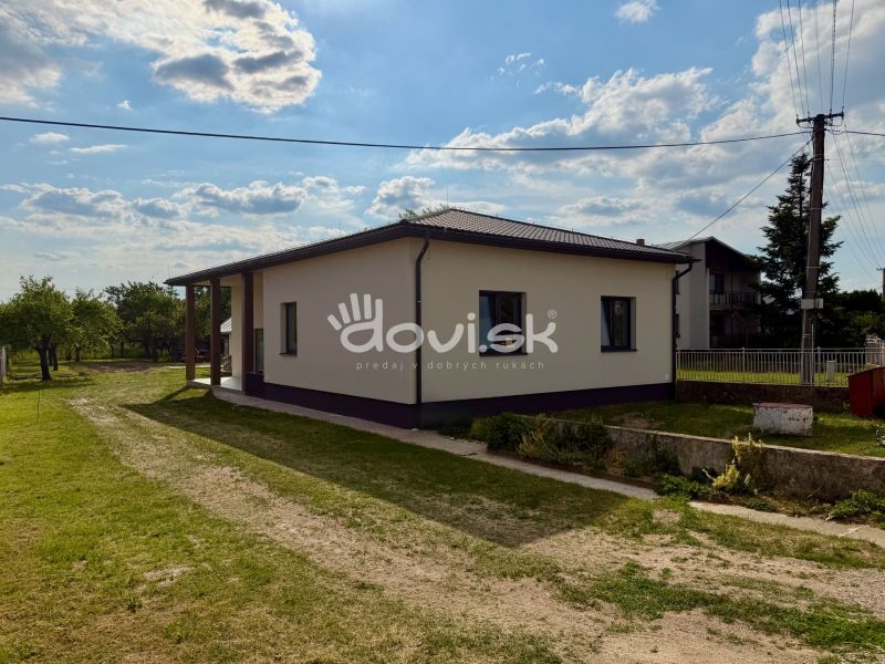 MODERNÝ 4-IZBOVÝ BUNGALOV | ZEMPLÍNSKA ŠIROKÁ - Rodinný dom v Zemplínskej Širokej obklopený zeleňou, jasná obloha nad strechou.