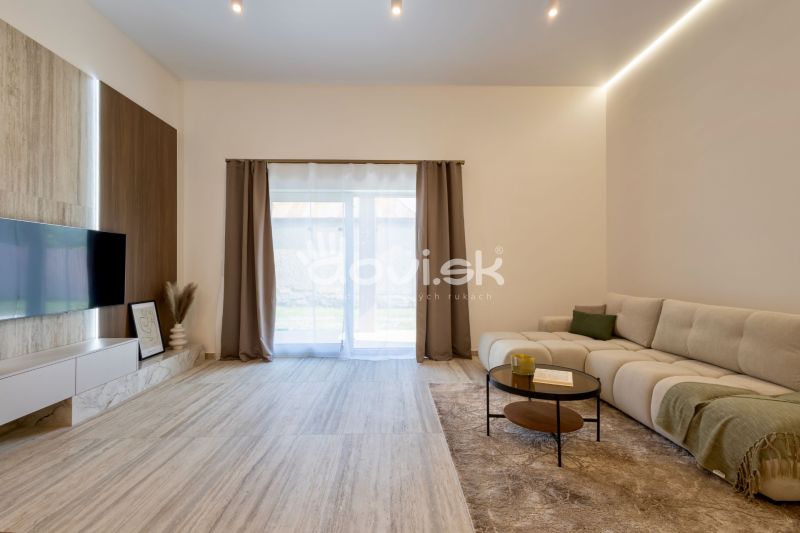 MODERNÝ 4-IZBOVÝ BUNGALOV | ZEMPLÍNSKA ŠIROKÁ - Obývačka rodinného domu so sedačkou, podlahou s dreveným dekorom a televízorom na stene.