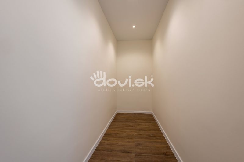 MODERNÝ 4-IZBOVÝ BUNGALOV | ZEMPLÍNSKA ŠIROKÁ - Úzka chodba v rodinnom dome s bielymi stenami a podlahou s dreveným dekorom.