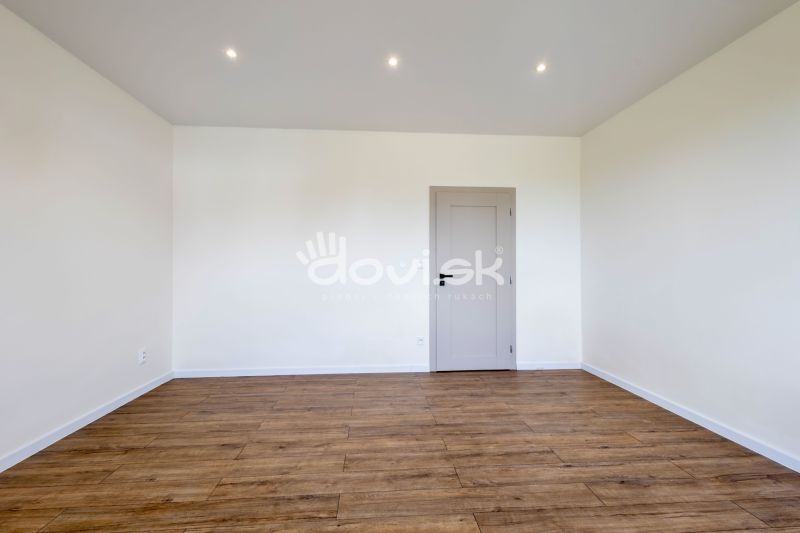 MODERNÝ 4-IZBOVÝ BUNGALOV | ZEMPLÍNSKA ŠIROKÁ - Miestnosť s podlahou s dreveným dekorom a bielymi stenami v rodinnom dome.