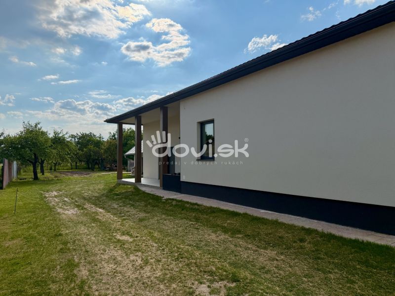 MODERNÝ 4-IZBOVÝ BUNGALOV | ZEMPLÍNSKA ŠIROKÁ - Exteriér rodinného domu v Zemplínskej Širokej obklopený trávnikom a stromami.