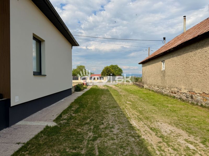MODERNÝ 4-IZBOVÝ BUNGALOV | ZEMPLÍNSKA ŠIROKÁ - Rodinný dom v Zemplínskej Širokej s trávnikom medzi budovami a upraveným chodníkom.