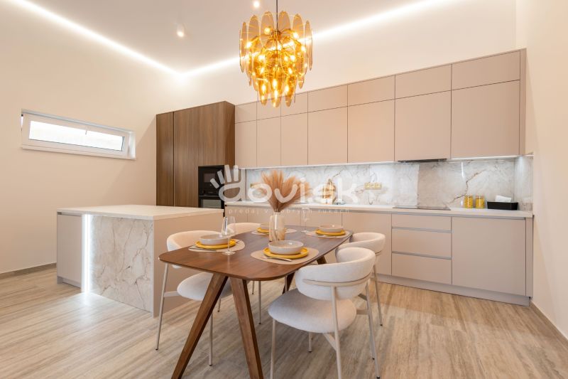 MODERNÝ 4-IZBOVÝ BUNGALOV | ZEMPLÍNSKA ŠIROKÁ - Jedáleň v rodinnom dome s dekorom mramoru na stenách a dreveným stolom.