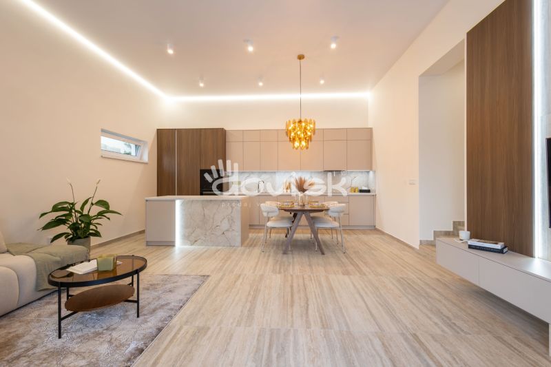 MODERNÝ 4-IZBOVÝ BUNGALOV | ZEMPLÍNSKA ŠIROKÁ - Kuchyňa a obývačka v rodinnom dome s dekoratívnym svietidlom a podlahou s dreveným dekorom.