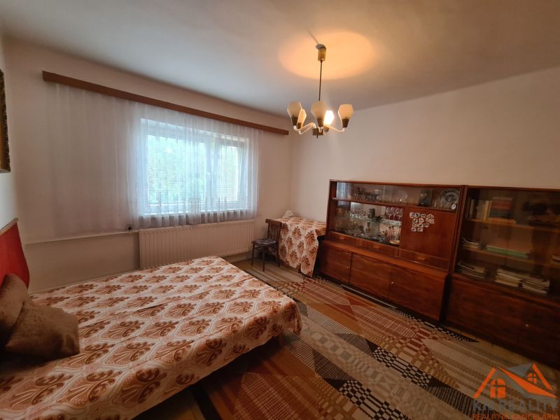 Na predaj rodinný dom Dulovce ! - Izba s rozkladacím gaučom, staršou vitrínou a závesom, v rodinnom dome.