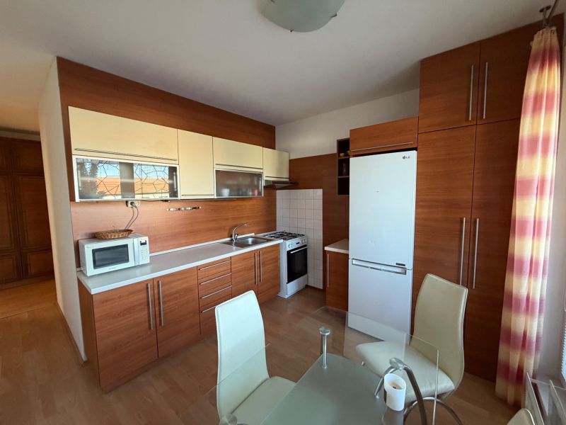 3 izbový byt s balkónom v meste Levice - Kuchyňa v 3-izbovom byte s dreveným dekorom a moderným zariadením.