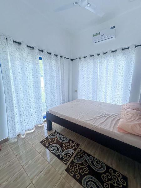 Dom pri pláži s vlastnou studňou a bazénom - Zanzibar, Uroa O578ZL - Spálňa v rodinnom dome s posteľou, závesmi a podlahou s dreveným dekorom.