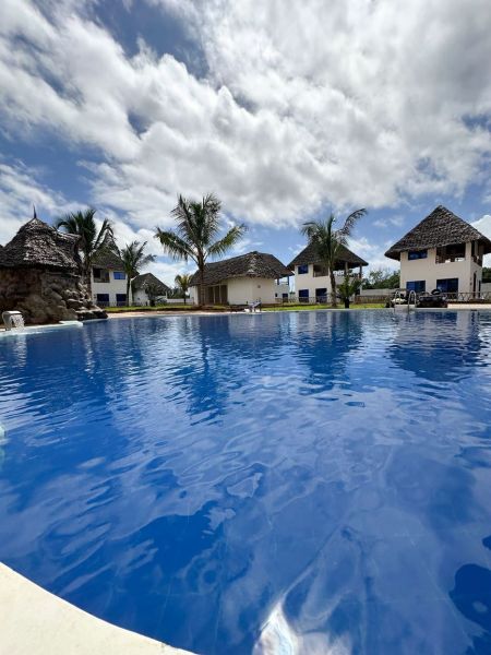 Dom pri pláži s vlastnou studňou a bazénom - Zanzibar, Uroa O578ZL - Bazen pri rodinných domoch v Zanzibare obklopený palmami.