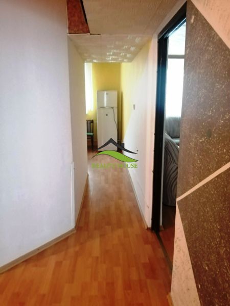 3 izbový byt na sidlisku Stráňany - Chodba v 3-izbovom byte s podlahou s dreveným dekorom, vedúca k chladničke.