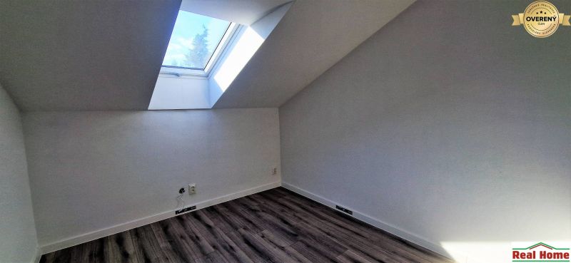 SENEC-4 izb. byt v rodinnom dome priamo v Senci - Podkrovná izba s veľkým strešným oknom a podlahou s dreveným dekorom v rodinnom dome.