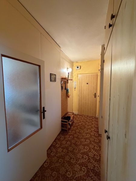 2 izbový byt pri vlakovej stanici v Nových Zámkoch - Chodba 2-izbového bytu so vstavanými skriňami a kobercovou podlahou.