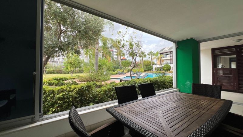 Exkluzívne na predaj Mezonetový apartmán Turecko- Side A205ZL - Krytá terasa so záhradným nábytkom a výhľadom na bazén v Side, Turecko.