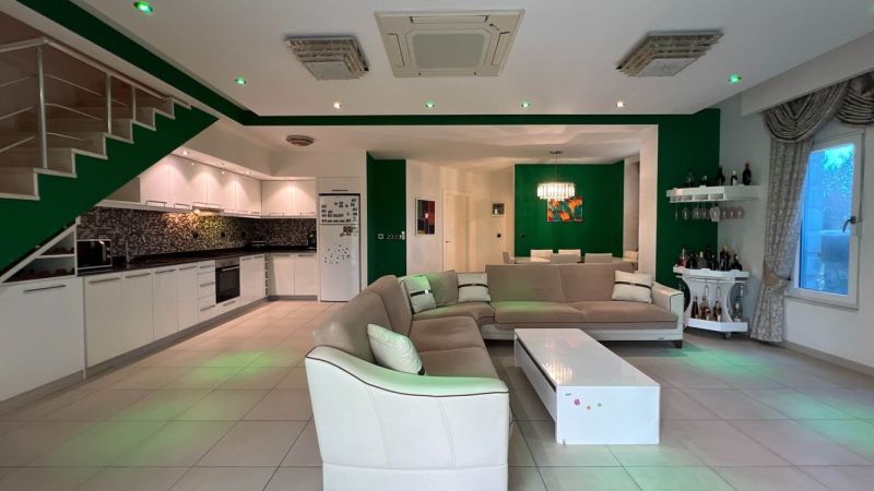 Exkluzívne na predaj Mezonetový apartmán Turecko- Side A205ZL - Obývacia izba so sedačkou, kuchyňou, jedálňou a bielym nábytkom v zvláštnej nehnuteľnosti.