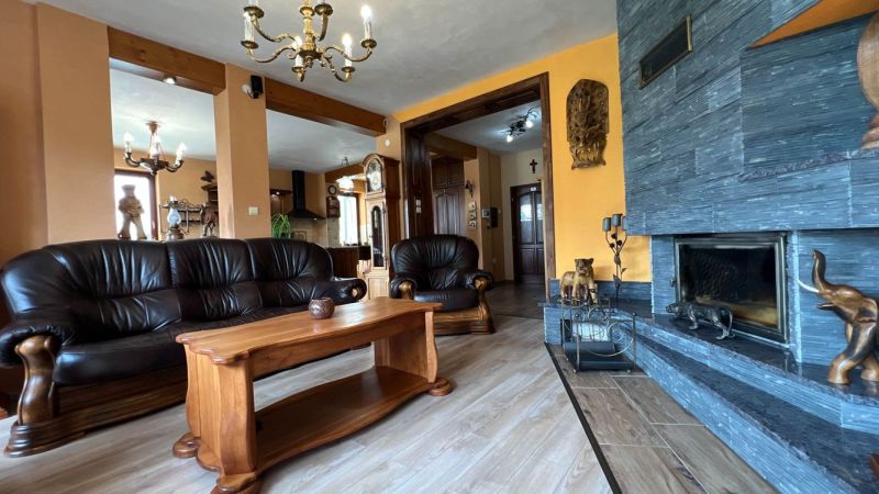 Na predaj penzion  – Štôla, Vysoké Tatry O560ZL - Kožená sedacia súprava a krb, podlaha s dreveným dekorom, elegantný interiér vily.