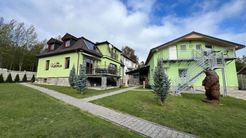 Na predaj penzion  – Štôla, Vysoké Tatry O560ZL - Vila vo Štôle, okres Poprad, Prešovský kraj s farebnou fasádou a záhradou.