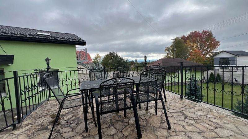 Na predaj penzion  – Štôla, Vysoké Tatry O560ZL - Terasa Vily v Štôle, okres Poprad, Prešovský kraj, so stolom a kovovými stoličkami.