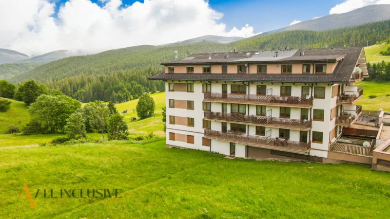 PRIESTRANNÝ 3 IZBOVÝ BYT S TERASOU | DONOVALY  - Bytový dom na Panorame v Donovaloch, obklopený lesmi a zelenými lúkami.