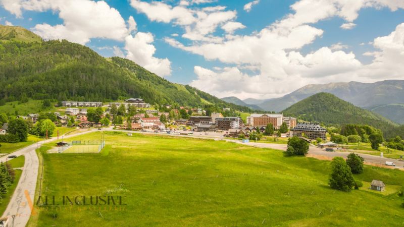 PRIESTRANNÝ 3 IZBOVÝ BYT S TERASOU | DONOVALY  - Panorama Donovaly, obklopená lúkami a horami, z výšky zobrazuje 3-izbové byty.