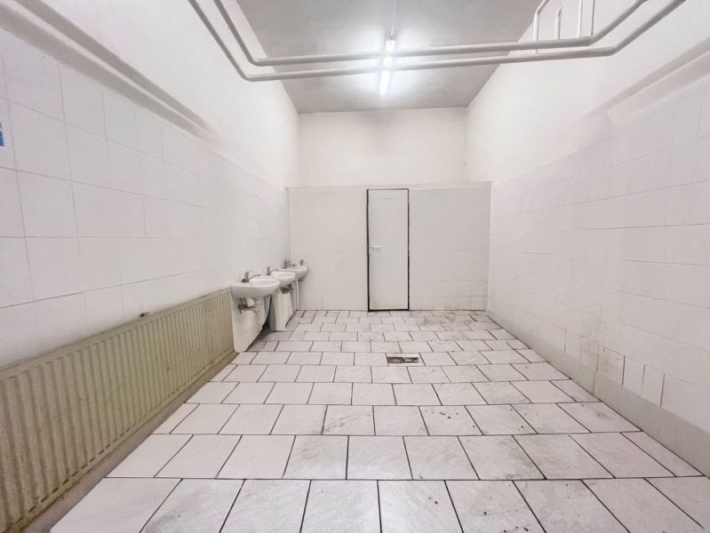 Na prenájom sklad 1474 m² s nakladacími rampami  - Banská Bystrica - Interiér skladov a hál s bielymi stenami, dvoma umývadlami a kachličkovou podlahou.