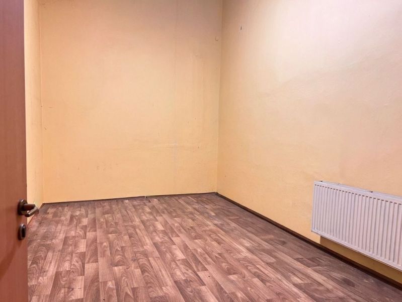 Na prenájom sklad 1474 m² s nakladacími rampami  - Banská Bystrica - Miestnosť s podlahou s dreveným dekorom, žltými stenami a radiátorom v Sklady a haly.