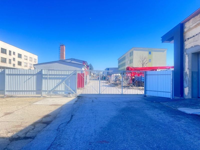 Na prenájom priestor 378 m² s vykurovaním — Banská Bystrica, Majer  - Výrobné priestory na Majerskej ceste v Banskej Bystrici s bránou a priemyselnými budovami.