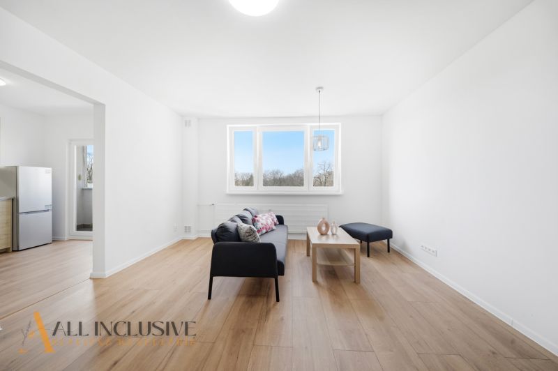 Na prenájom veľkometr. 1-izb. byt s loggiou, Šamorín - Svetlá obývačka 1-izbového bytu s podlahou s dreveným dekorom a pohovkou.