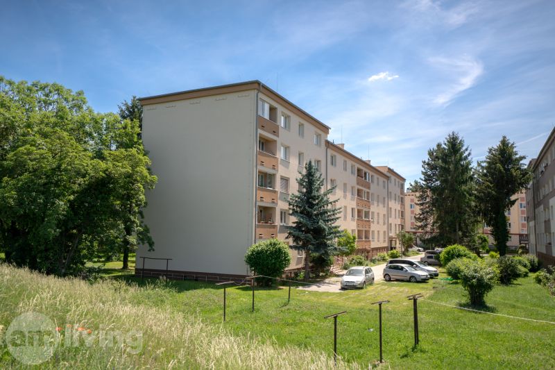 TOP LOKALITA - 3i 67m2 + loggia - Švermova Trenčín - Bytové domy na ulici Švermova v Trenčíne s okolitou zeleňou a zaparkovanými autami.