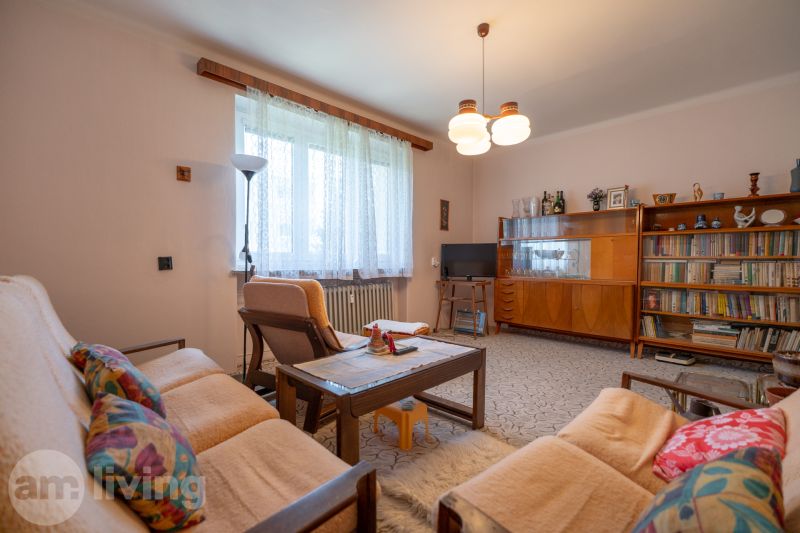TOP LOKALITA - 3i 67m2 + loggia - Švermova Trenčín - Obývacia izba v 3-izbovom byte s retro nábytkom, pohovkou a knižnicou.