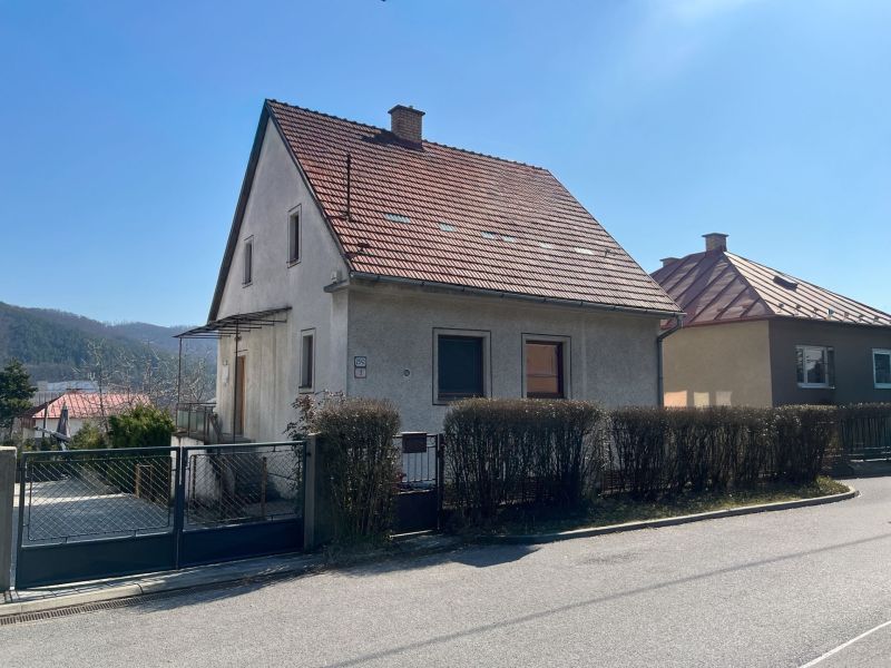 ROVINATÝ POZEMOK  S PRÍSTUPOM Z DVOCH STRÁN+ RODINNÝ DOM – B. Bystrica - Rodinný dom v Podháji s červenou strechou a záhradkou, okres Banská Bystrica.