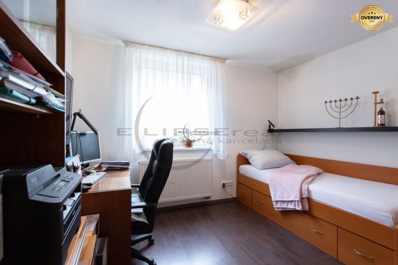 NA PREDAJ priestranný 7-izbový rodinný dom s dvojgarážou v Marianke - Izba v rodinnom dome s posteľou, pracovným stolom a podlahou s dreveným dekorom.