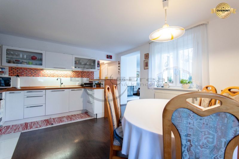 NA PREDAJ priestranný 7-izbový rodinný dom s dvojgarážou v Marianke - Kuchyňa v rodinnom dome s bielymi skrinkami, oranžovým obkladom a podlahou s dreveným dekorom.