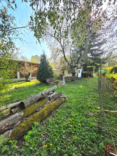 : Záhrada s chatkou, Košice – Krásna, 716 m², elektrina - Záhrady na Ulici 1. mája v Košiciach - mestskej časti Krásna, drevené klády a zeleň.