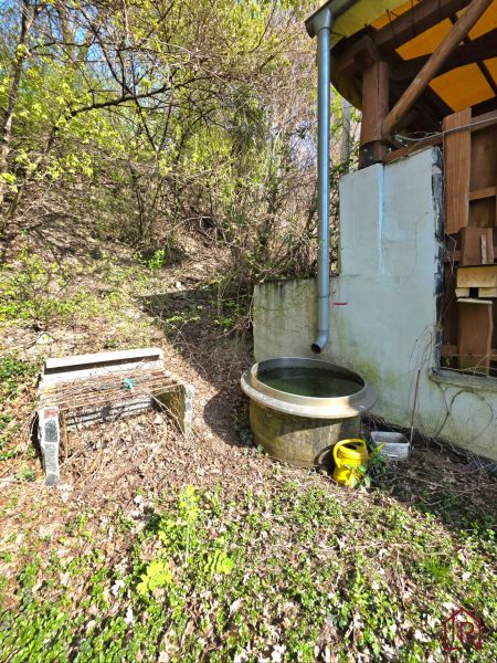 : Záhrada s chatkou, Košice – Krásna, 716 m², elektrina - Drevená konštrukcia chaty a dažďový sud v záhrade na Ulici 1. mája, Krásna.
