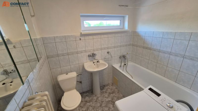 Tehlový 2-izbový byt s vlastným kúrením vo Vrbovom - Kúpeľňa v 2-izbovom byte s vaňou, umývadlom, práčkou a kachličkovanými stenami.
