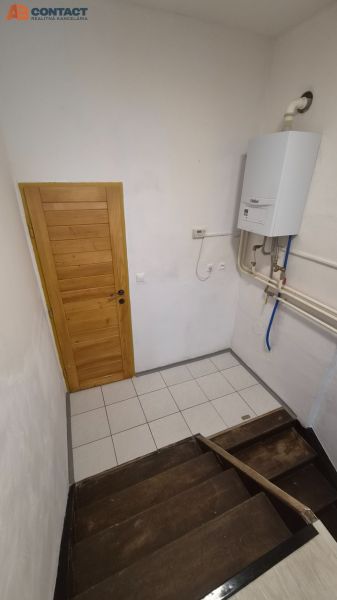 Tehlový 2-izbový byt s vlastným kúrením vo Vrbovom - Schodisko s drevenými stupňami a plynovým kotlom v 2-izbovom byte.