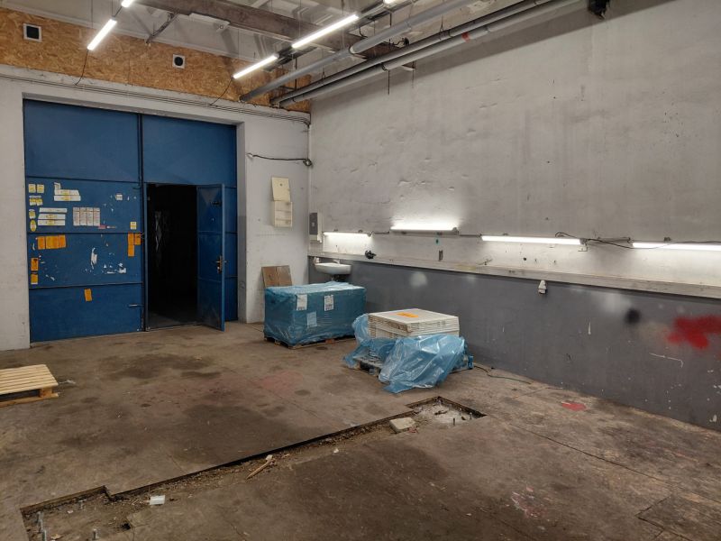 Prenájom skladu 55 m2 na Tomášikovej ul. v Ružinove - Sklady a haly s modrými dverami, osvetlením a materiálmi na podlahe s dreveným dekorom.