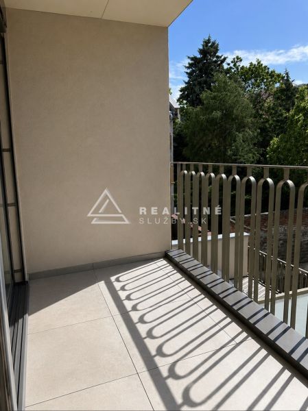 NOVOSTAVBA , BAŠTOVÁ 48 M2 2-IZBOVÝ BYT S LOGGIOU  - Balkón so zábradlím a výhľadom na zeleň v 2-izbovom byte.
