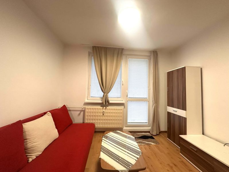 ☎️ 0918/197 701 Na prenájom garsónka s balkónom aj s výťahom   v centr - Rekreačný apartmán s červenou sedačkou, dreveným dekorom podlahy a skriňou s dekorom dreva.