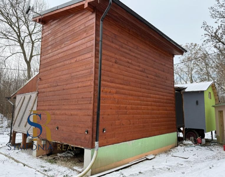 Rekreačná chata pri Váhu - Dlhá nad Váhom - bez rezervačnej zálohy - Chata v Dlhej nad Váhom s dreveným obkladom, zateplená bočná strana. Zima, snehová pokrývka.